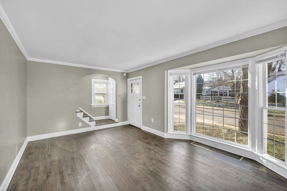 Empty living room with a bay window, before staging