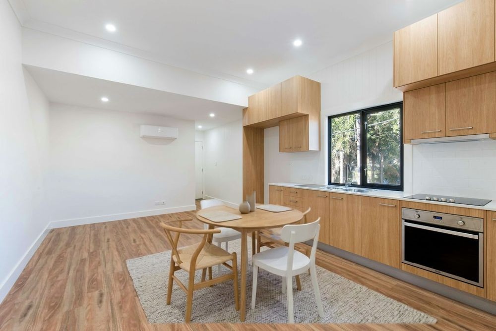 The same kitchen after staging: dining table, chairs and rug